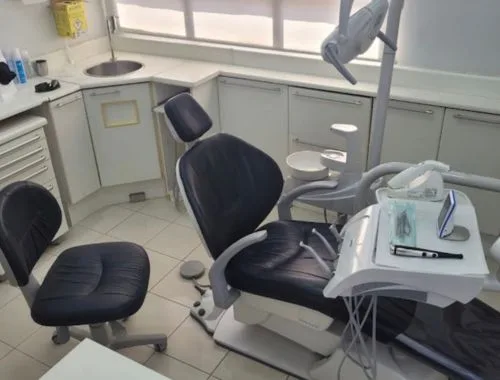 Consultório odontológico moderno do Dr. Ciro Capitani em Santos, iluminação clara e equipamentos de ponta, paleta em tons neutros e verde-petróleo, fotografia profissional ultra-realista