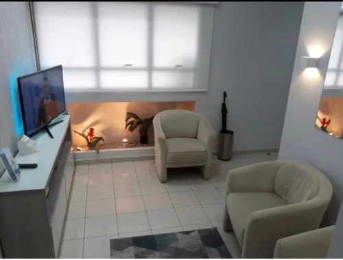 Sala de espera acolhedora do consultório Dr. Ciro Capitani, decoração em tons neutros e ambiente tranquilo, iluminação suave, fotografia profissional